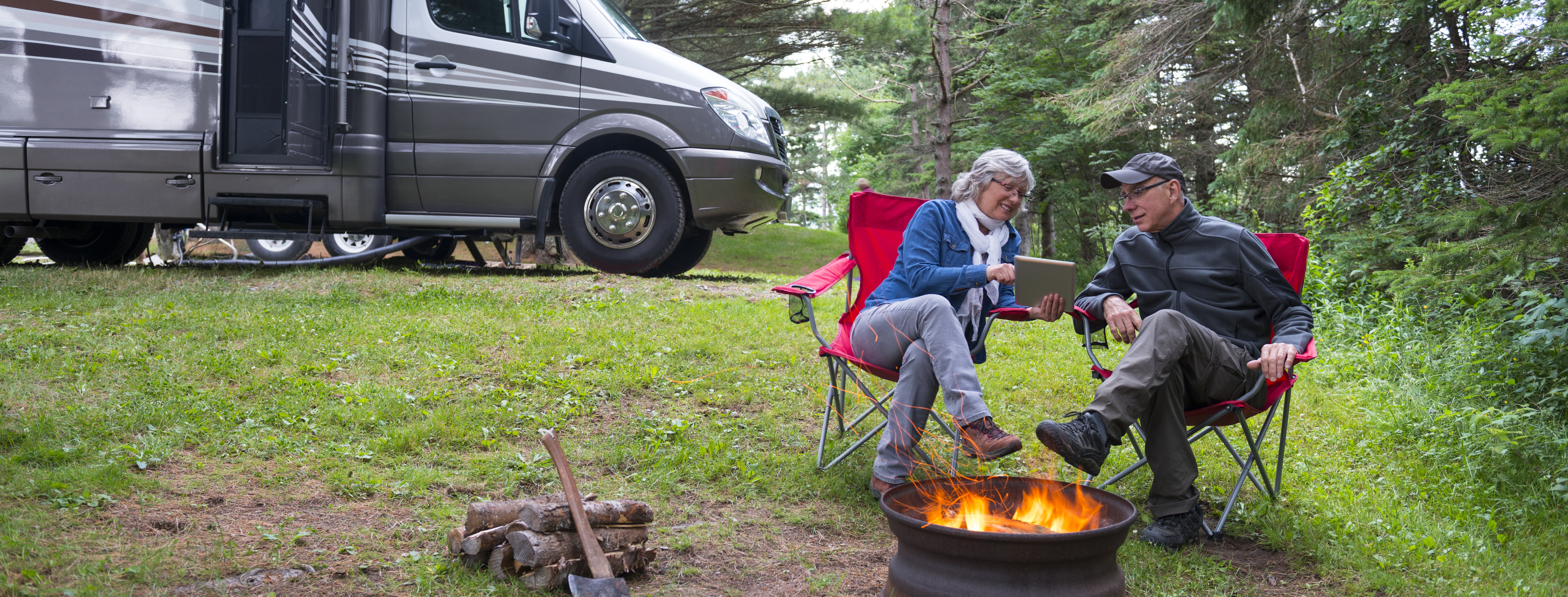 Couple enjoying a fire by their RV